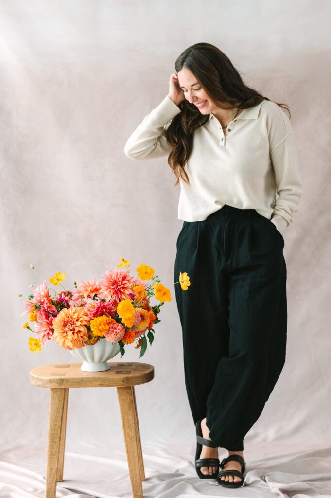 Portrait of Richmond Florist standing next to her floral arrangement.