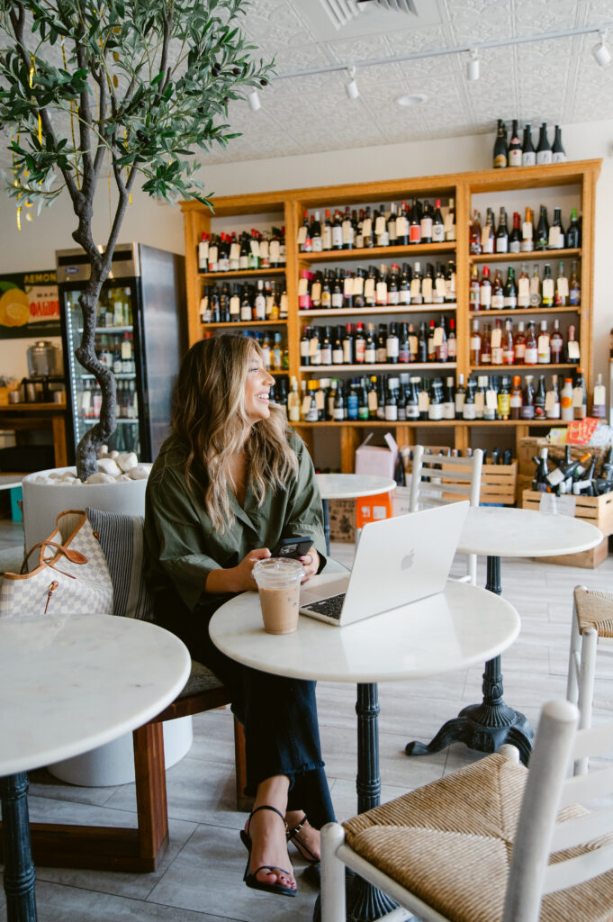 Branding photography of a woman enjoying a work session at a Richmond café with her laptop and iced coffee.