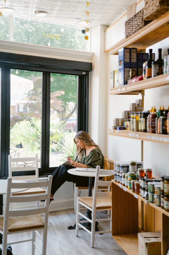 Branding photography lifestyle image of a woman working at a Richmond café by the window.