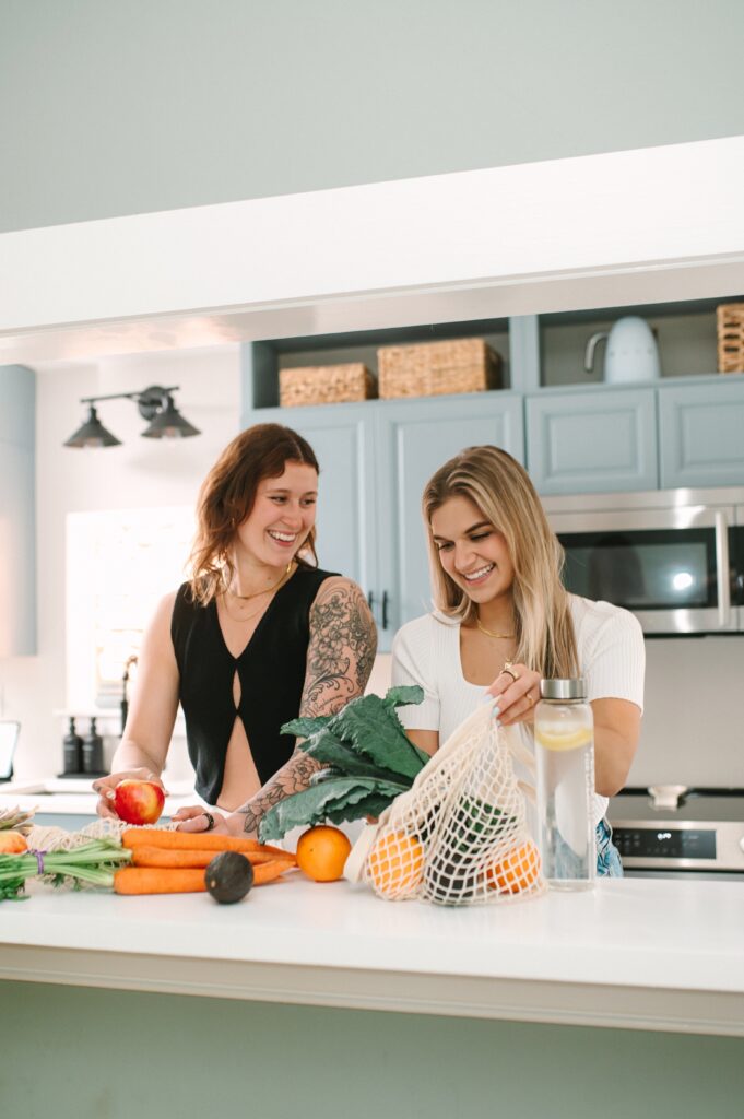 Branding photography lifestyle scene of two women preparing fresh produce in a modern kitchen during a Richmond brand photoshoot.