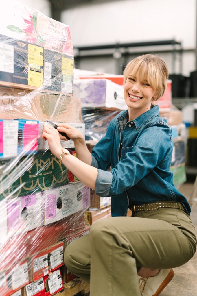 Behind the scenes branding photography showing a team member unpacking flower shipments at Wholesale Flower Market.