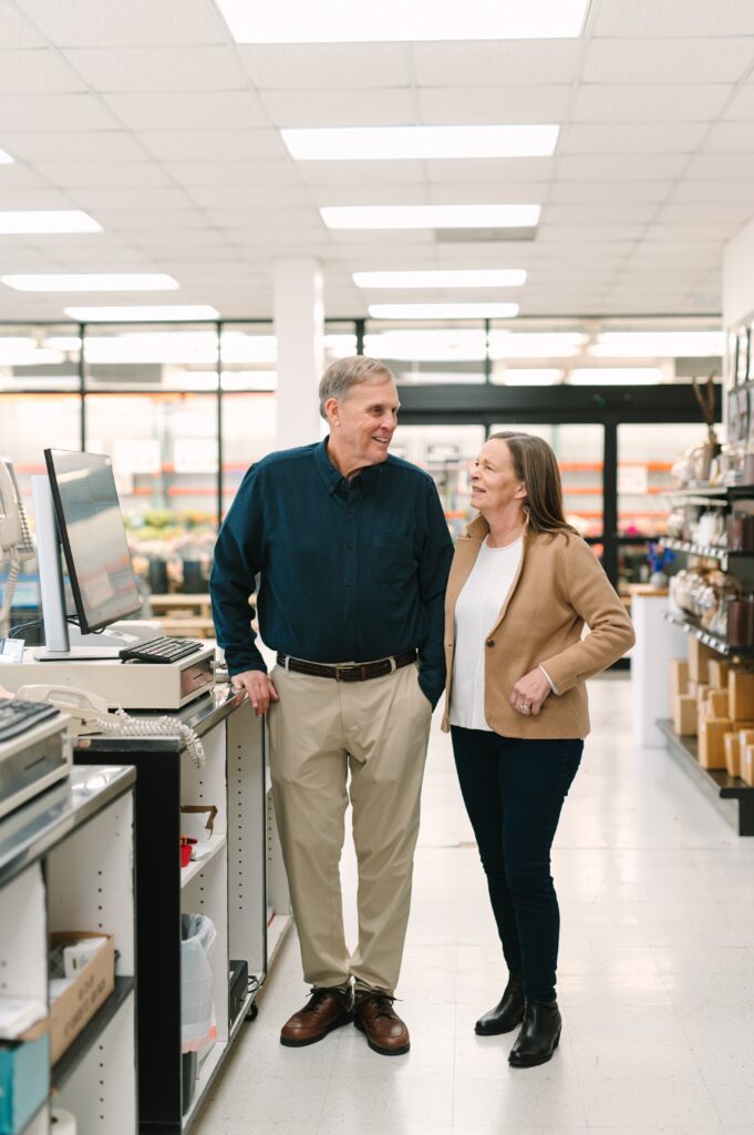 Original owners of Wholesale Flower Market standing behind the register.
