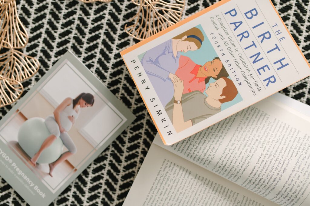 Flat lay of birth education books and resources styled for a doula branding photoshoot