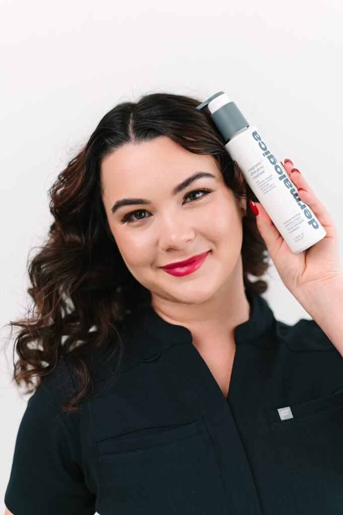 Esthetician holding professional skincare products during a branding photoshoot