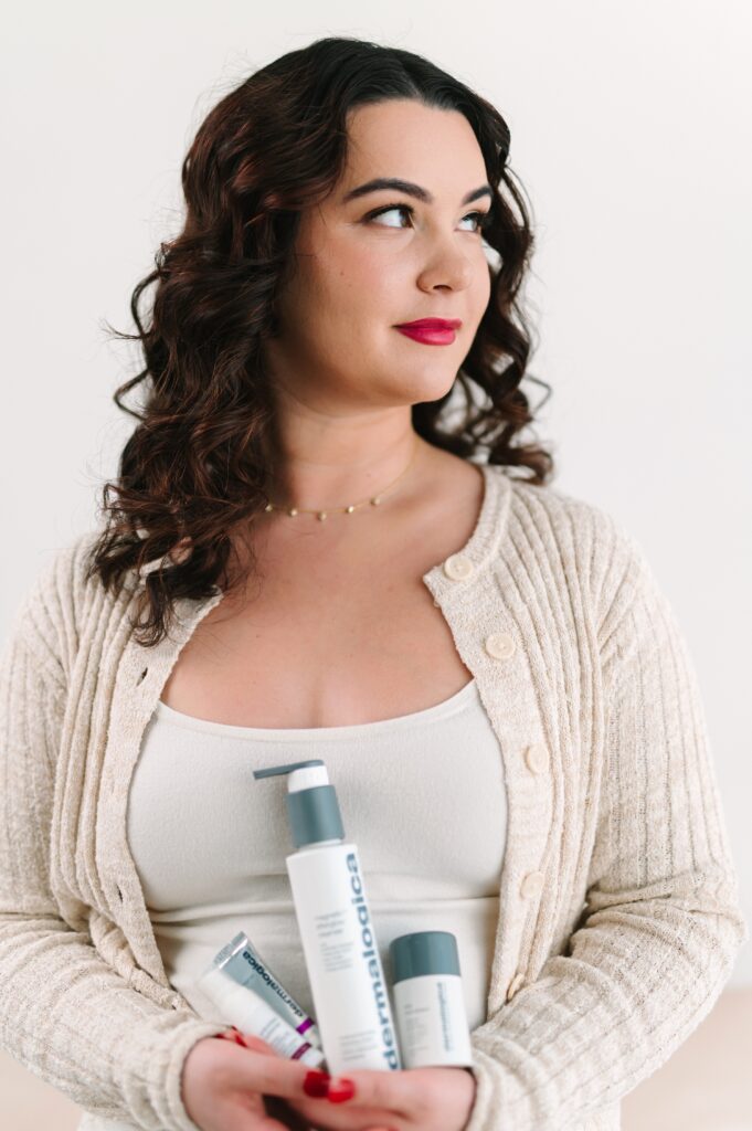 Esthetician holding professional skincare products during a branding photoshoot