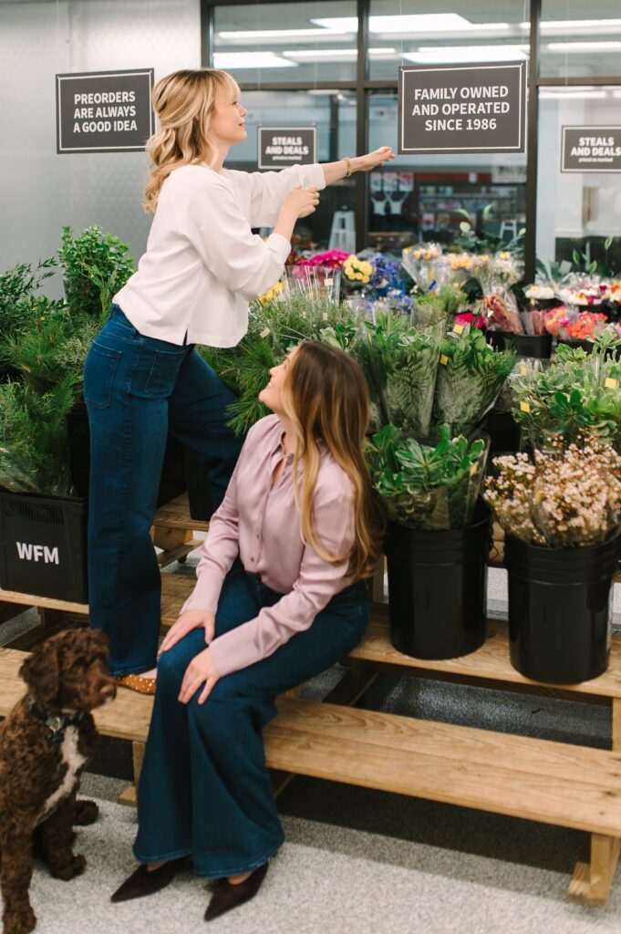 Wholesale Flower Market owners adjusting a family-owned sign during branding photography.