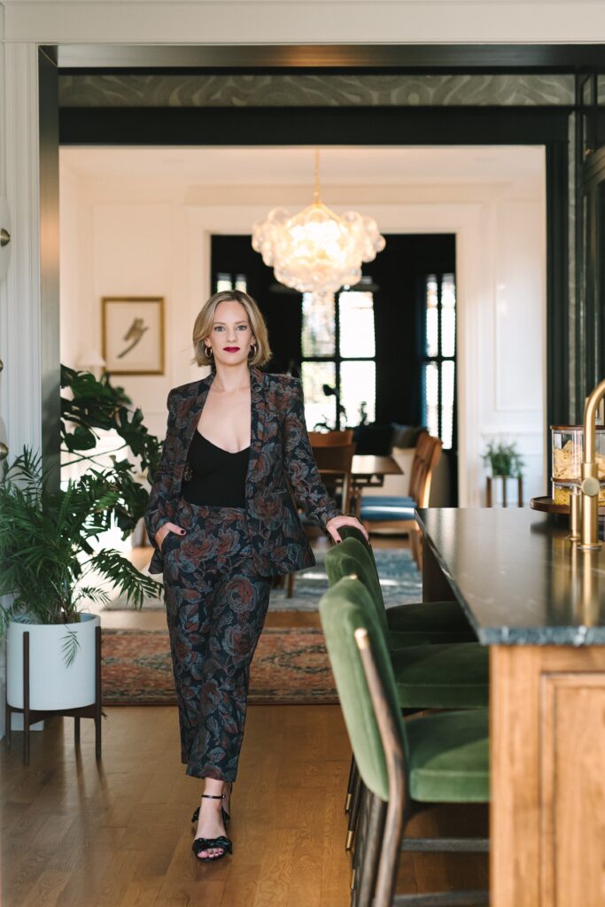 Luxury interior designer standing confidently in a styled dining room during a branding photoshoot