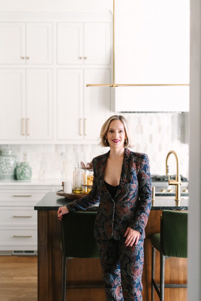 Luxury interior designer standing confidently in a styled dining room during a branding photoshoot
