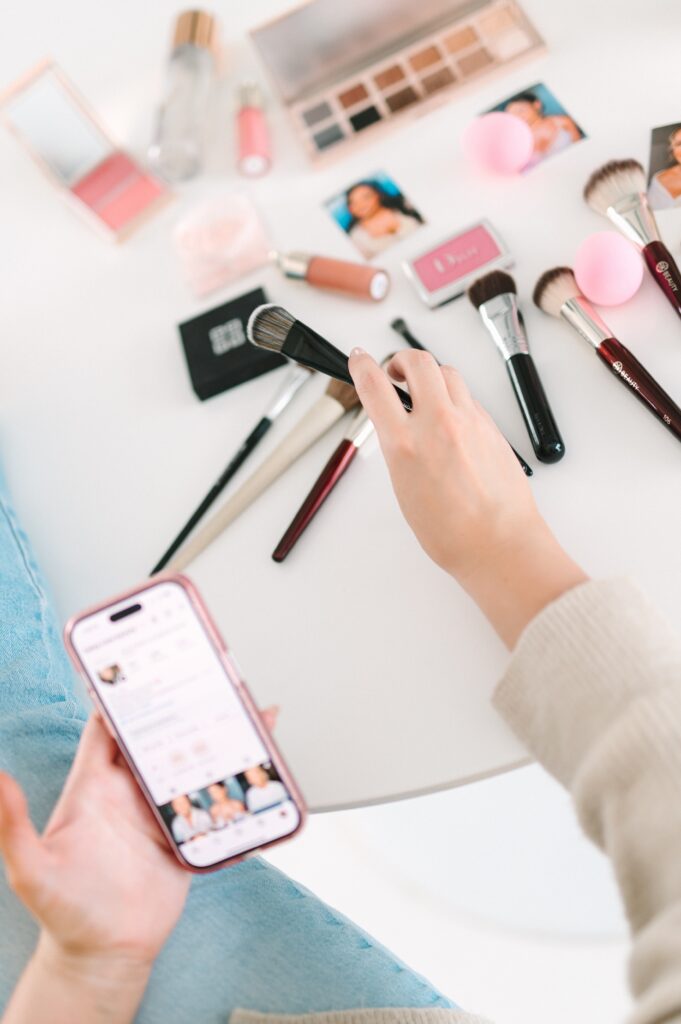 Flat lay of makeup brushes and beauty products styled for makeup artist branding photos.