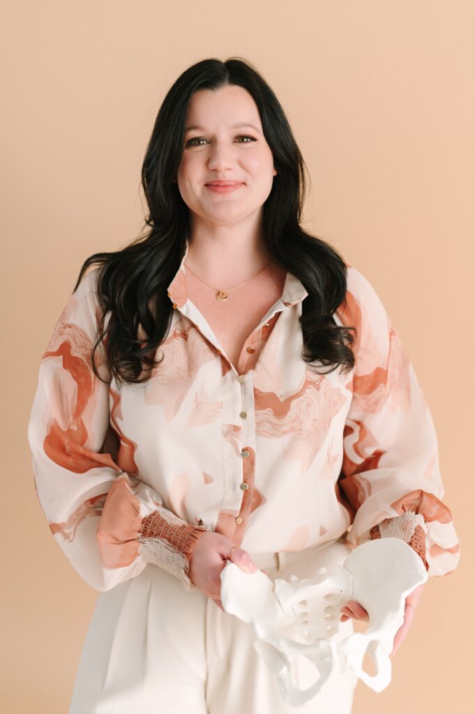 Professional portrait of a doula holding a pelvic model during a branding photoshoot