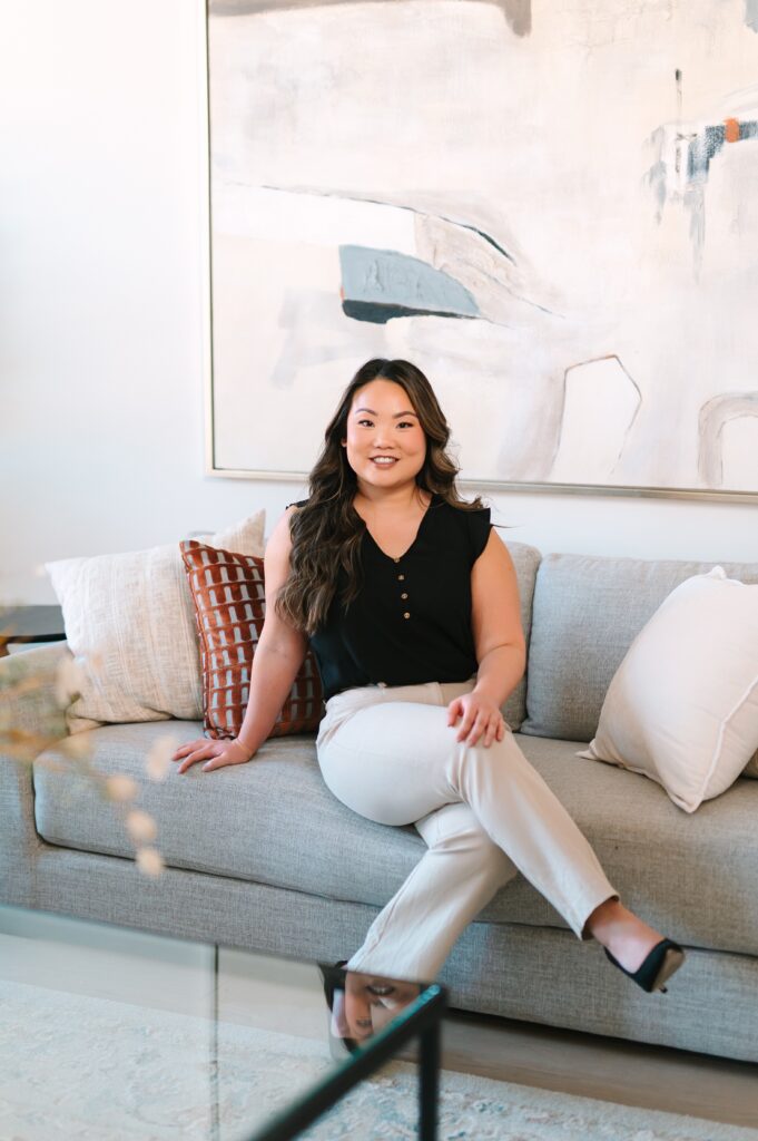 Real estate agent seated on a sofa during a lifestyle branding photoshoot in a modern living room