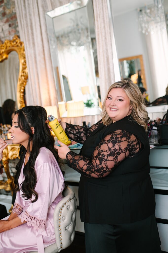 Wedding hair artist styling a bride’s hair during a wedding beauty appointment.
