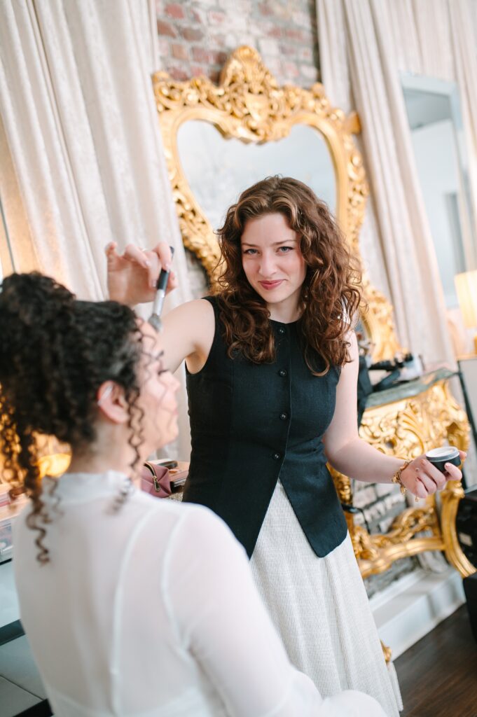 Wedding makeup artist applying makeup to a bride during a professional beauty session.