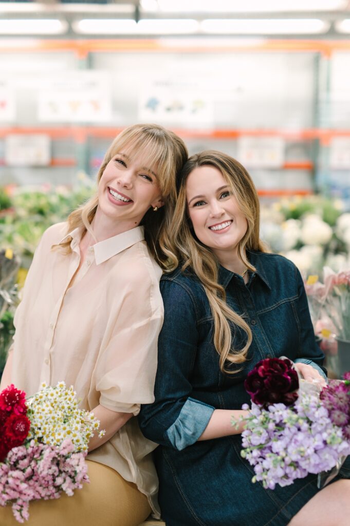 Two wholesale flower market business owners holding fresh flower bouquets in the market