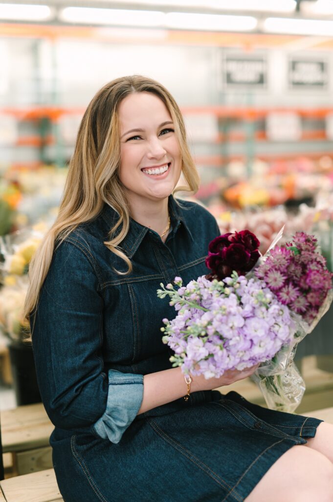 Wholesale flower market owner smiling while holding a bouquet of fresh flowers