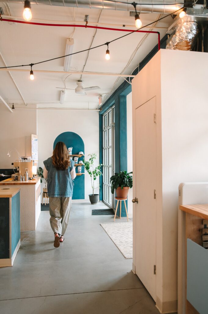 Wide view of boutique owner walking through a coffee shop during a branding session in Richmond VA