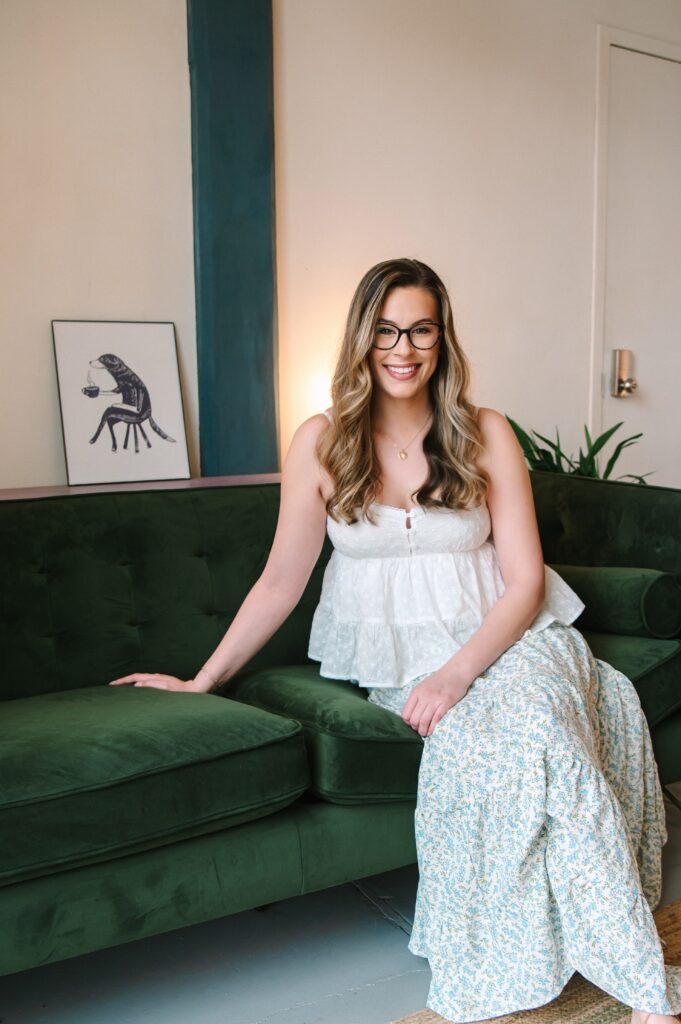Boutique owner sitting on green couch during a studio branding photoshoot in Richmond VA