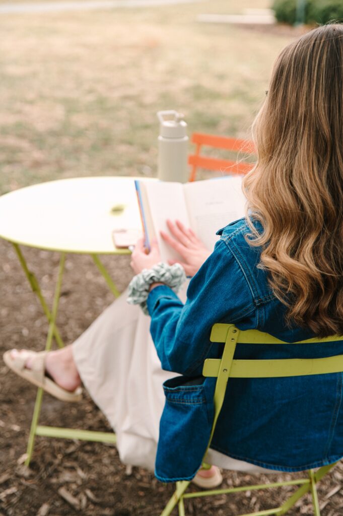 Over-the-shoulder view of boutique owner reading outdoors during a branding photoshoot in Richmond VA
