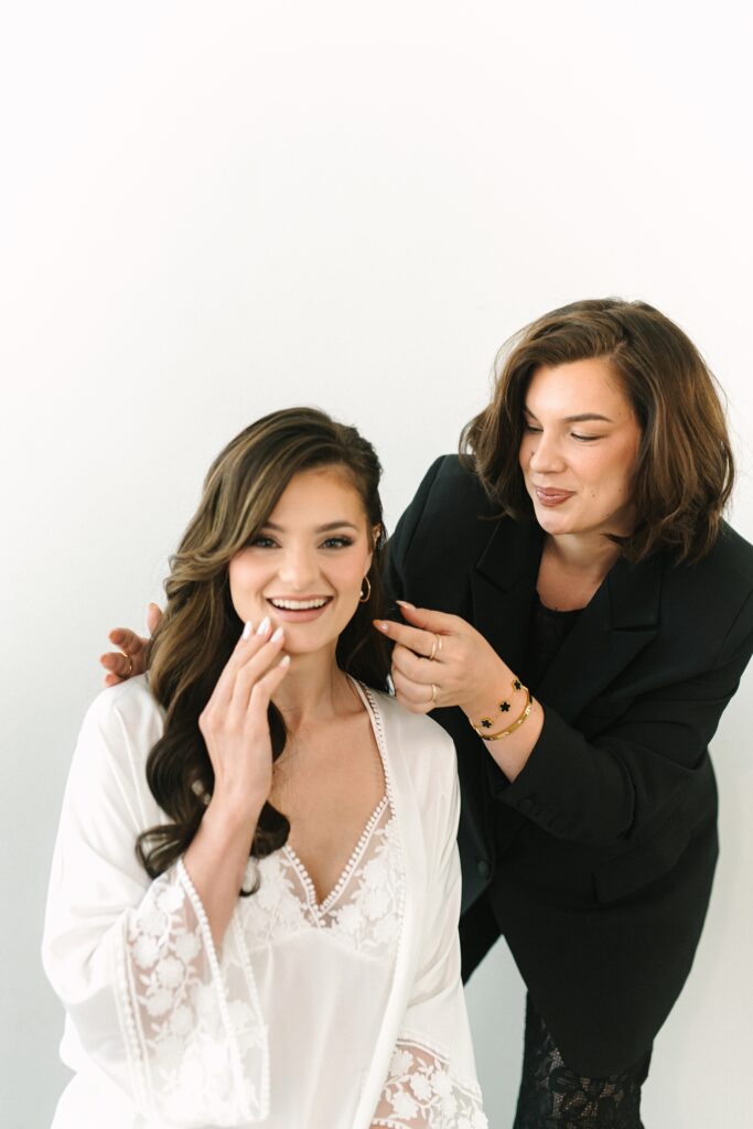 Makeup artist fixing a bride's hair during a branding photography session.