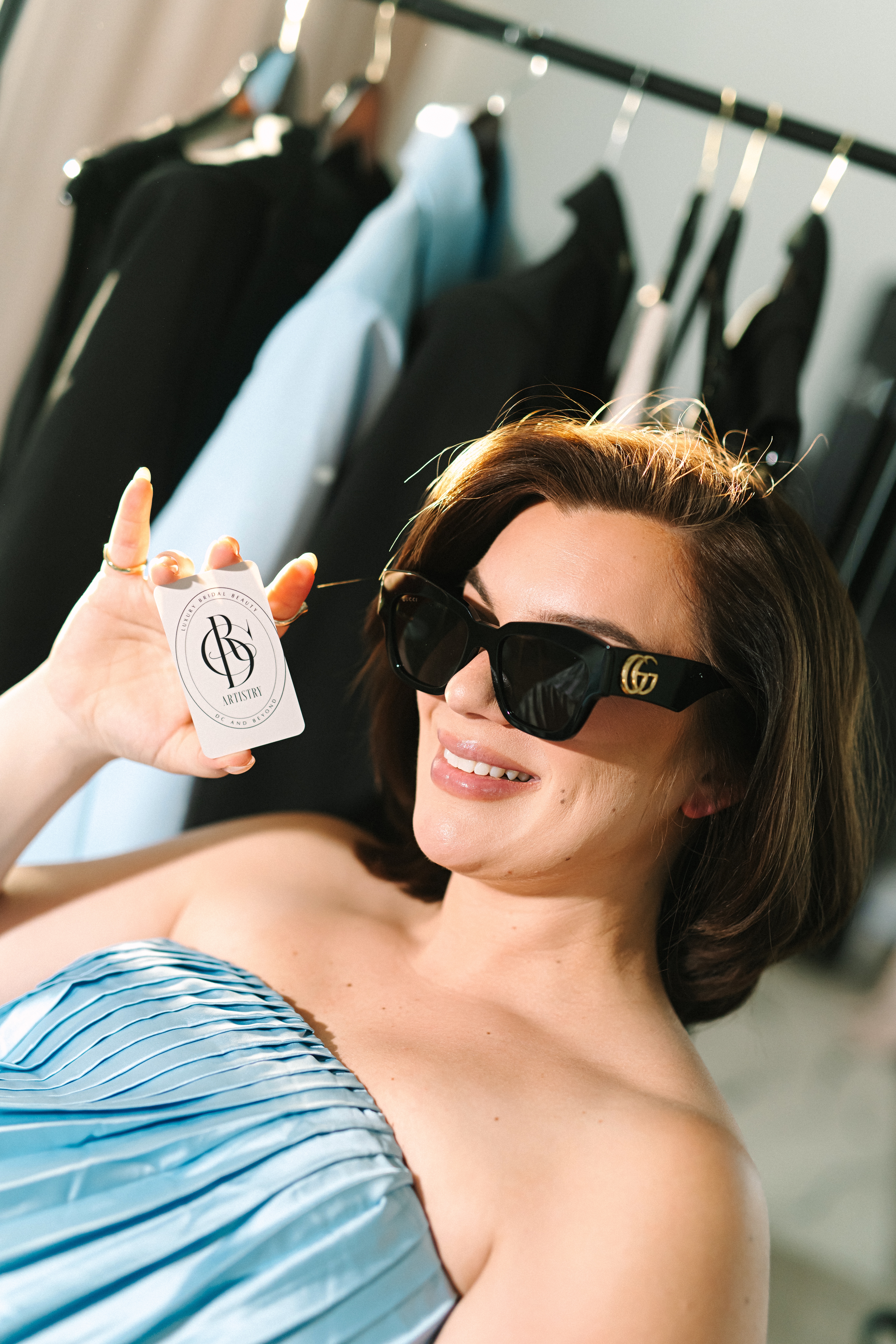 Luxury wedding makeup artist showing branded business card during personal branding photoshoot