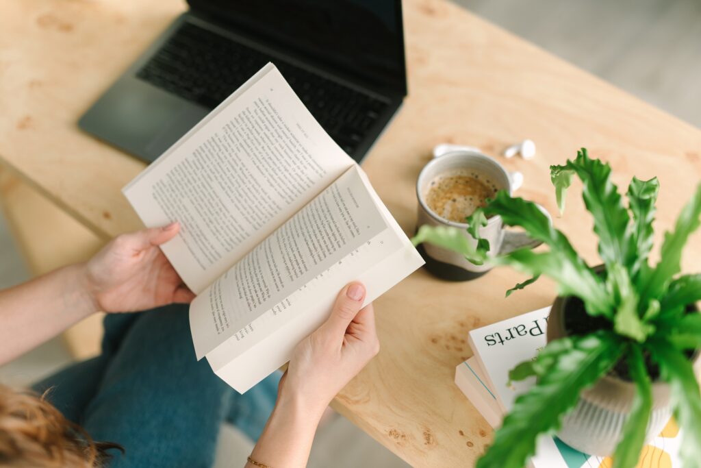 detail photo of a therapist holding a book next to a plant during a branding photography session