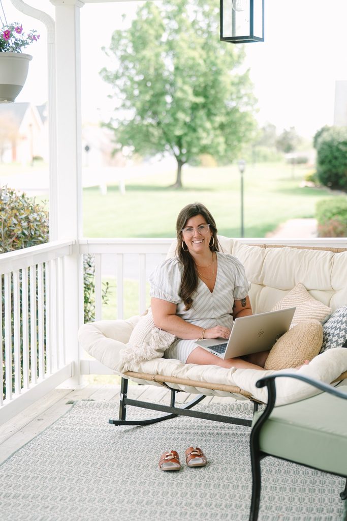 Sparrow Home Loans team member working on a laptop from a cozy cushioned seat on a front porch in Richmond VA